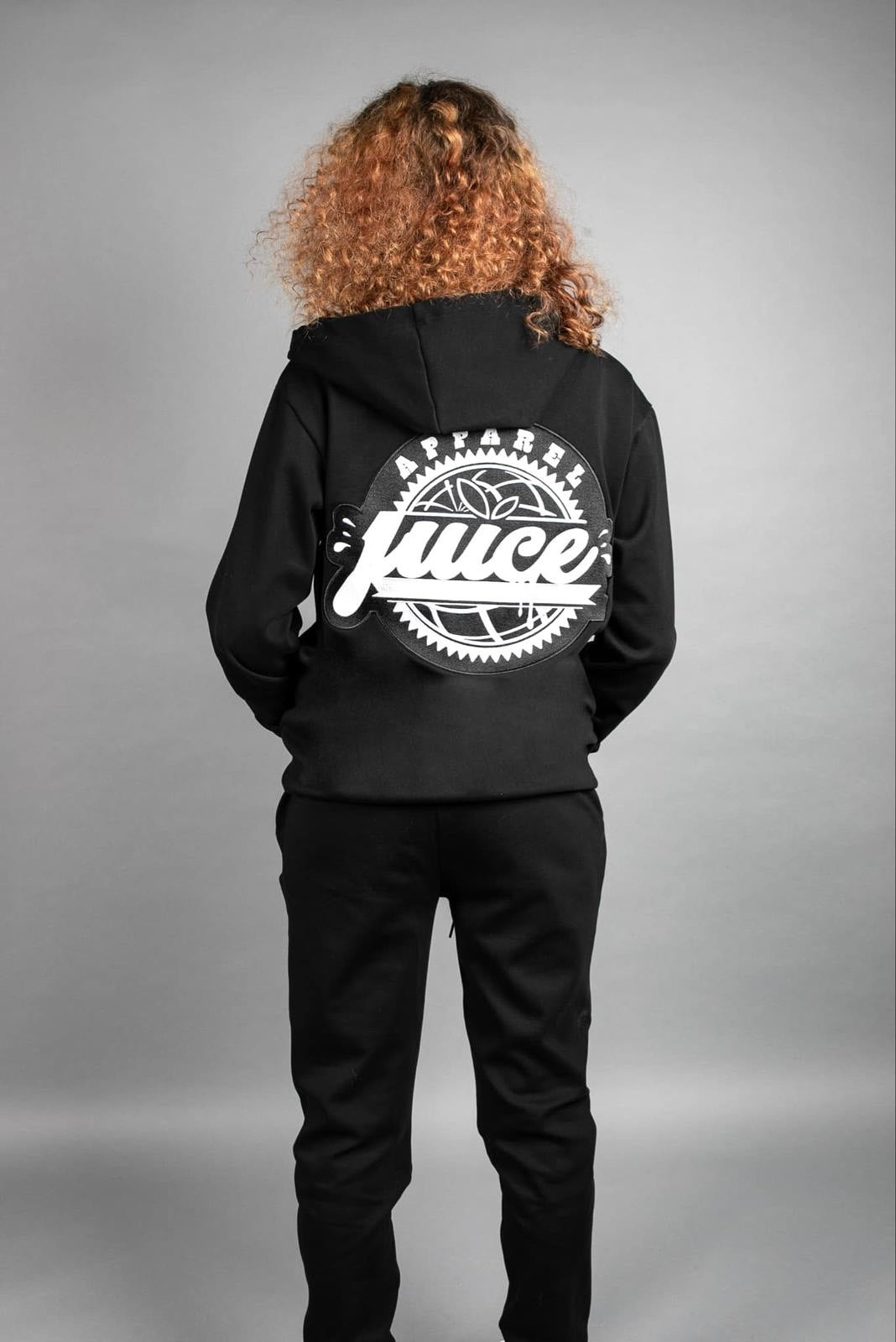 Person wearing a black hoodie with a juice logo on the back against a gray background
