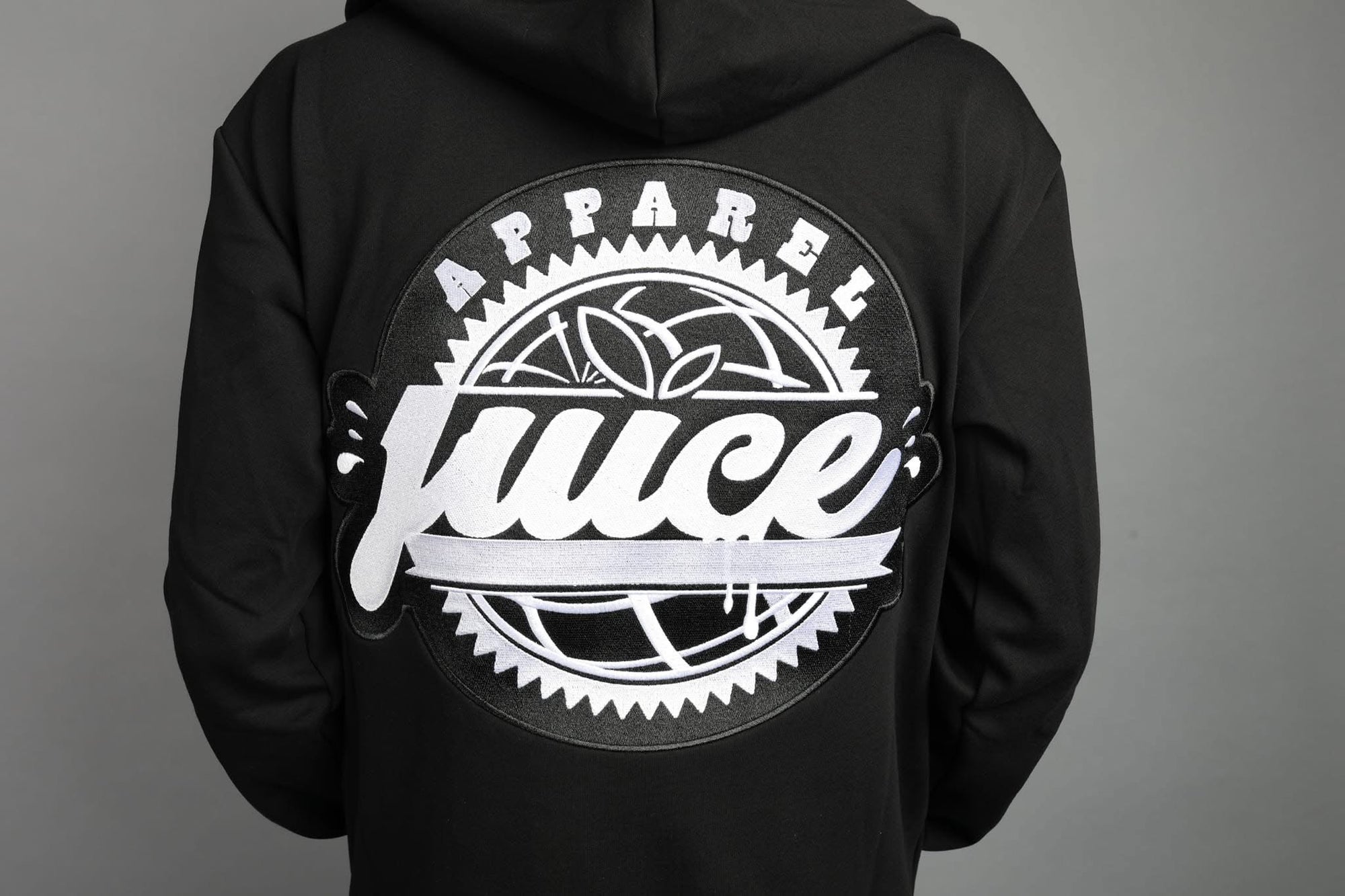Black hoodie with 'Apparell Juice' logo on the back against a gray background